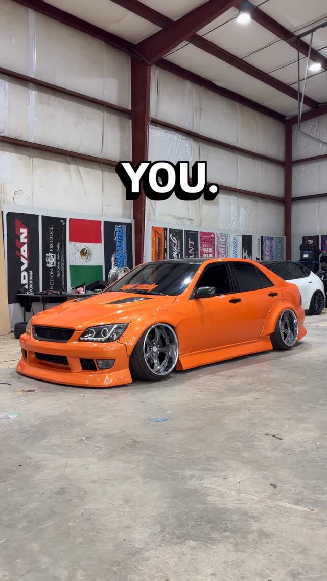 Slammed orange sedan with aggressive fitment on bronze wheels.
